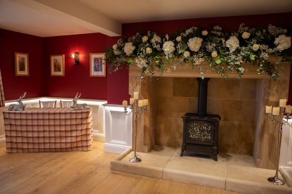 Table with checked cloth and fireplace with flower garland