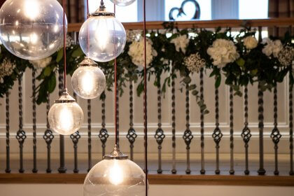 Lights in hall showing flowers decorating landing bannister