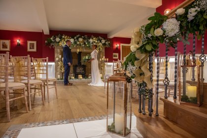 Close up of couple in wedding standing in front of decorated fireplace