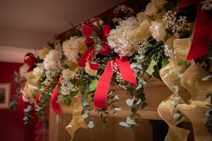 Garland of flowers decorating top of fireplace