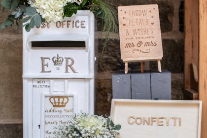 Box of confetti and replica postal box on table